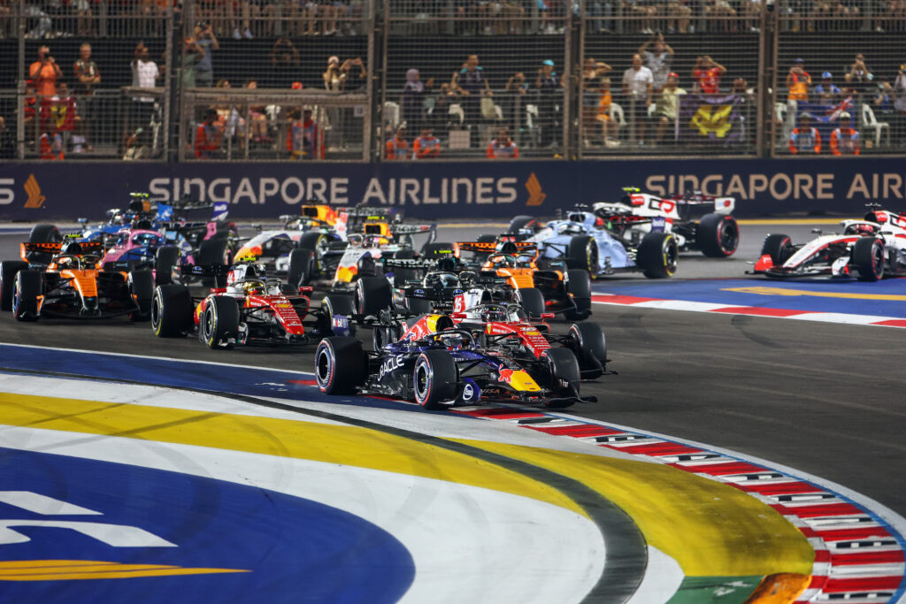 Max Verstappen of the Netherlands driving the (3) Oracle Red Bull Racing RB22 Red Bull Ford Powertrains leads Charles Leclerc of Monaco driving the (16) Scuderia Ferrari SF-26 Lewis Hamilton of Great Britain driving the (44) Scuderia Ferrari SF-26 and the rest of the field at the start during the F1 Grand Prix of Singapore at Marina Bay Street Circuit on October 11, 2026 in Singapore, Singapore. (Photo by Sam Bloxham/LAT Images)